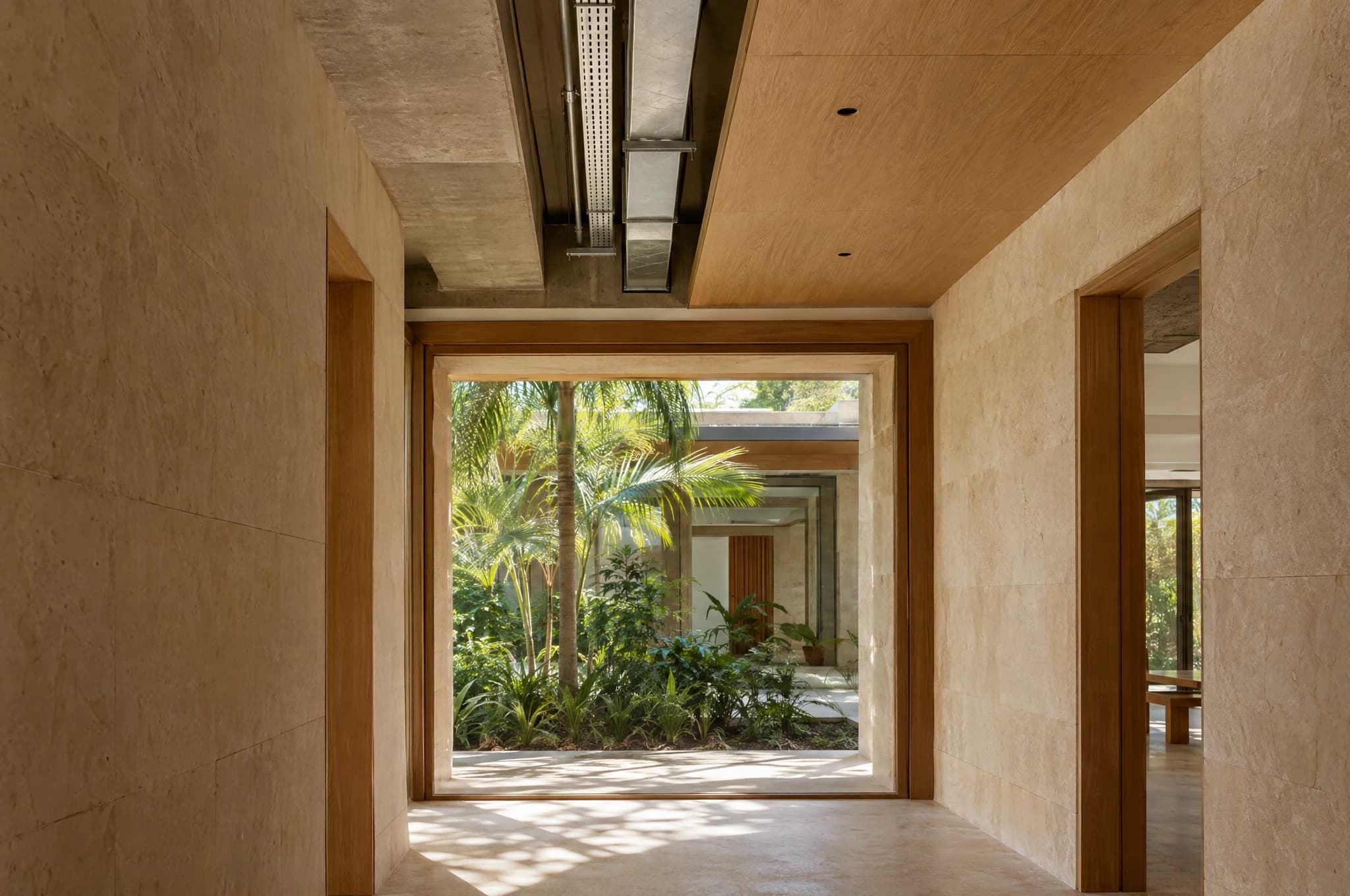 Concept photograph of a tropical interior during fit-out, showing a concrete beam, coordinated ventilation route and timber opening